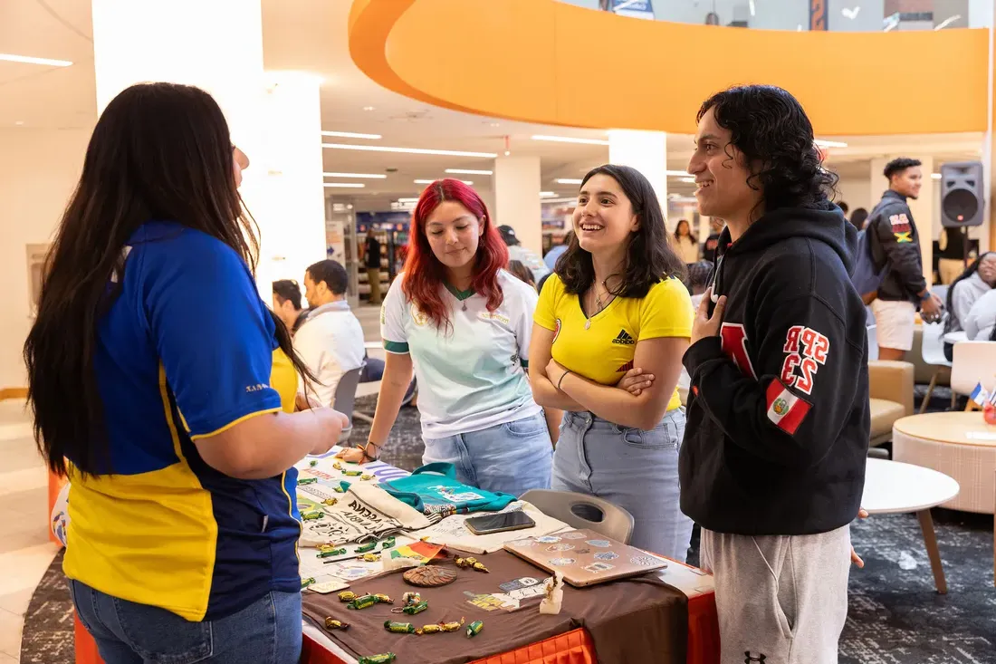 students chat around table in the Schine Student Center.